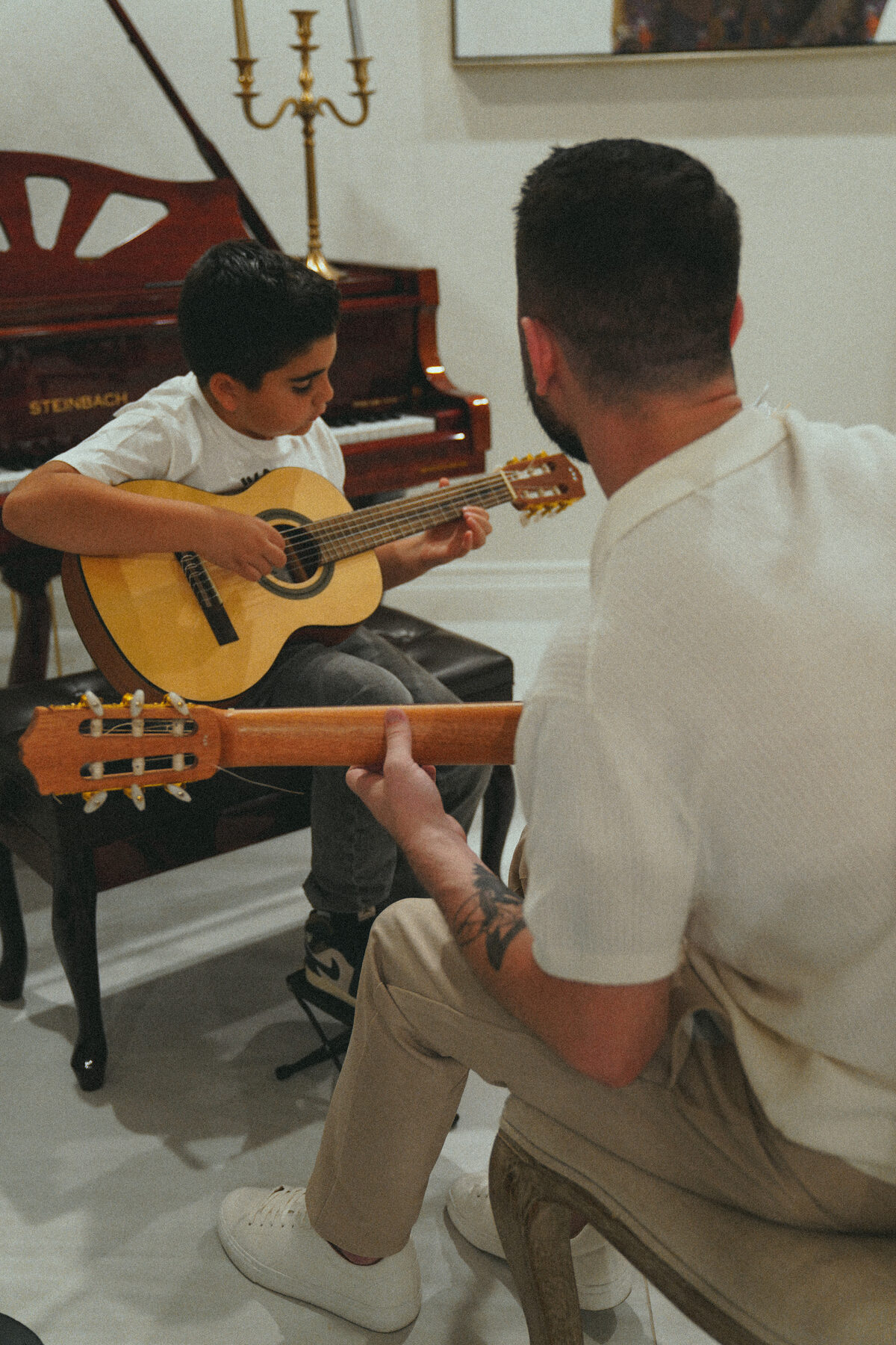 Young student playing guitar with instructor